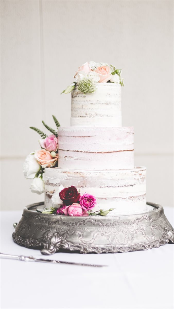 Three-tier semi-naked buttercream cake with blush, burgundy and white roses