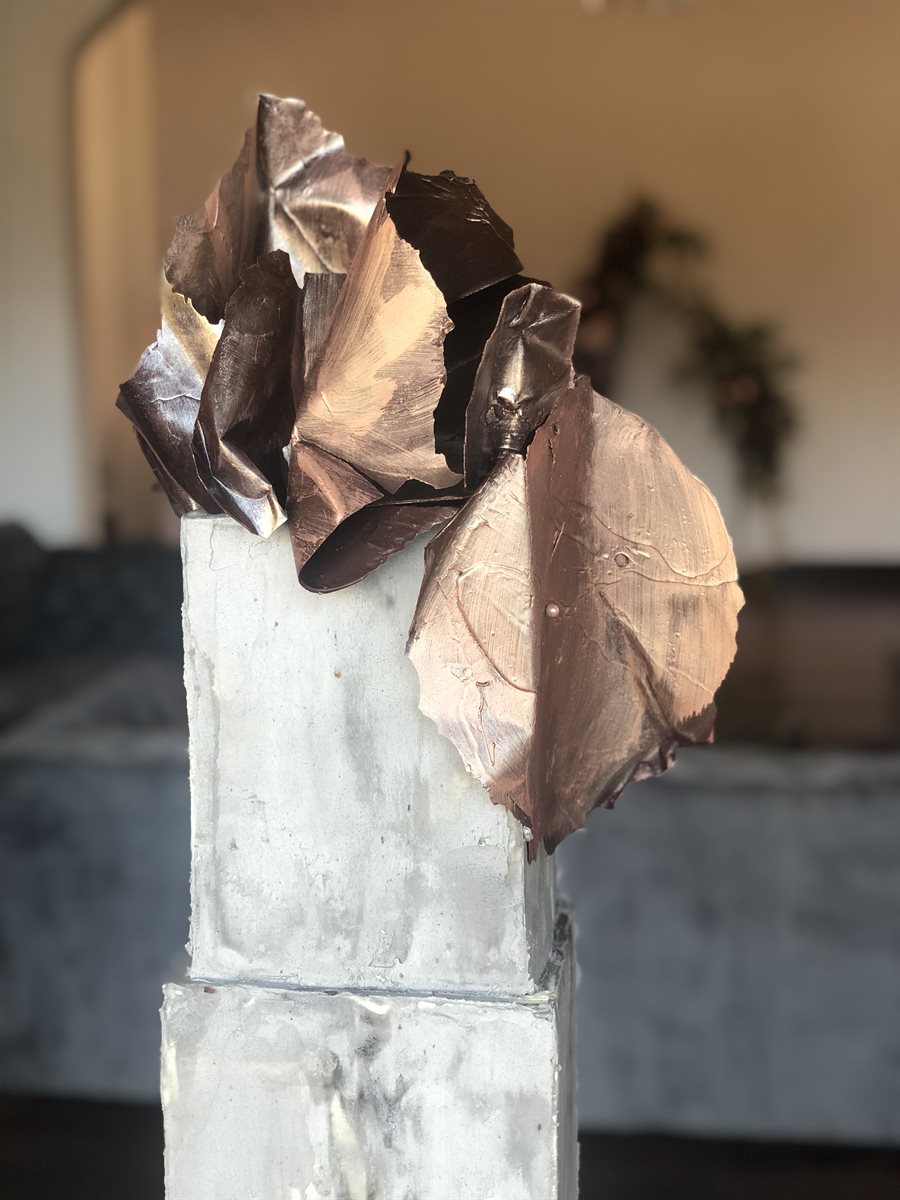 Bronze and copper-leafed sculpted chocolate petals crowning a textured grey concrete-look cake column
