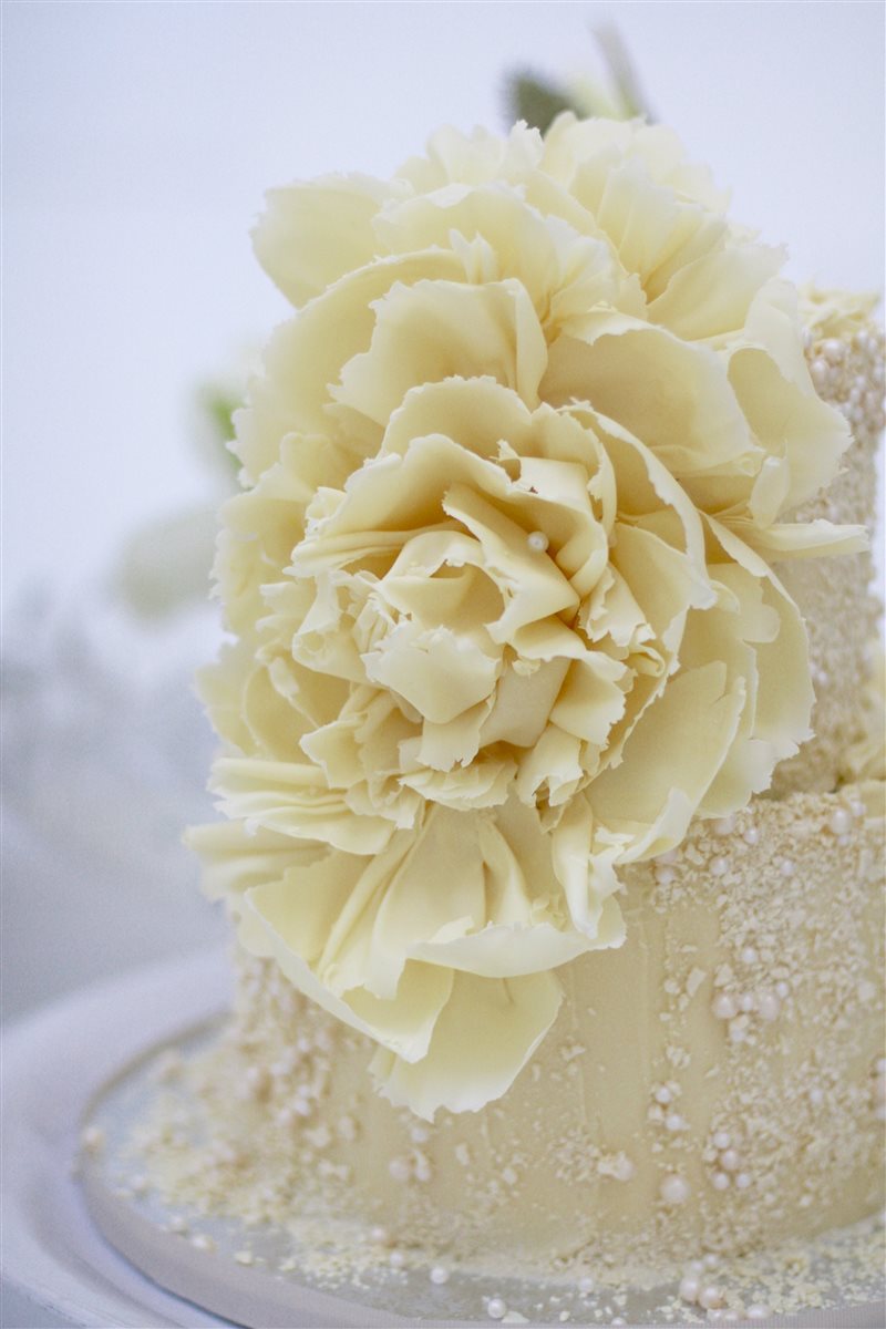 Close-up hand-sculpted white chocolate peony in full bloom