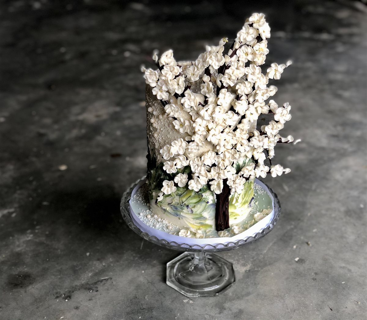 Single-tier cake hand-painted with cherry blossom tree in bloom