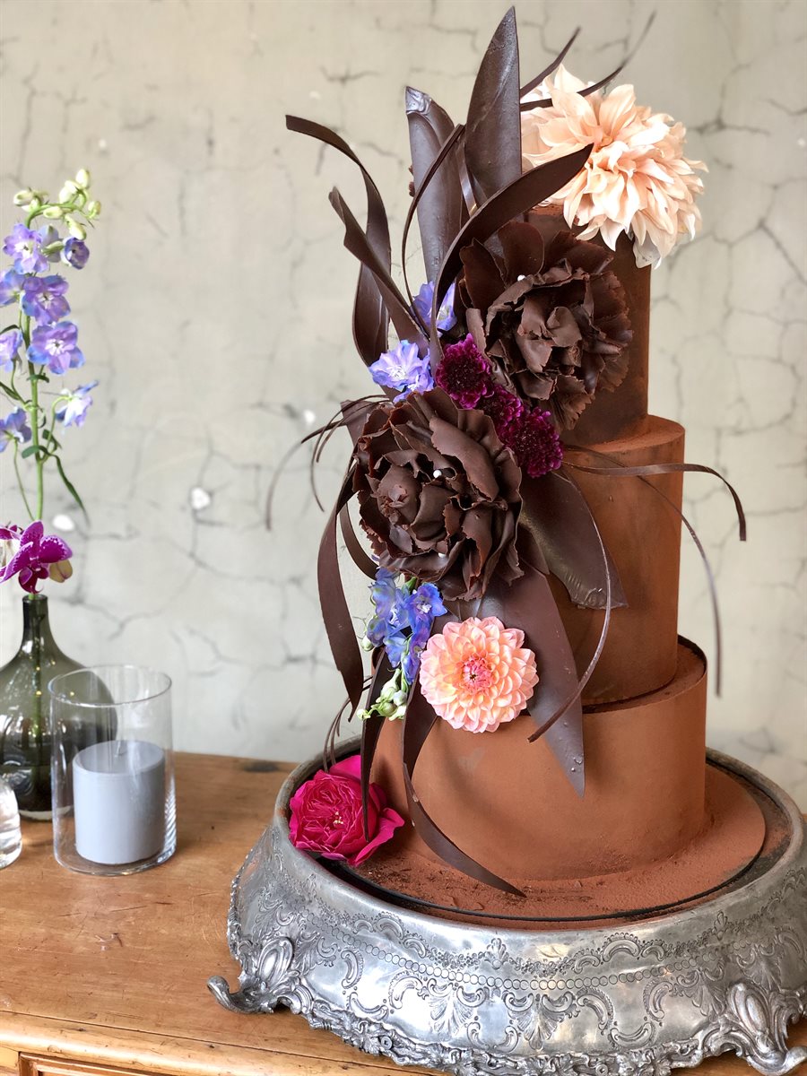 Chocolate cake with hand-sculpted flowers and delphiniums