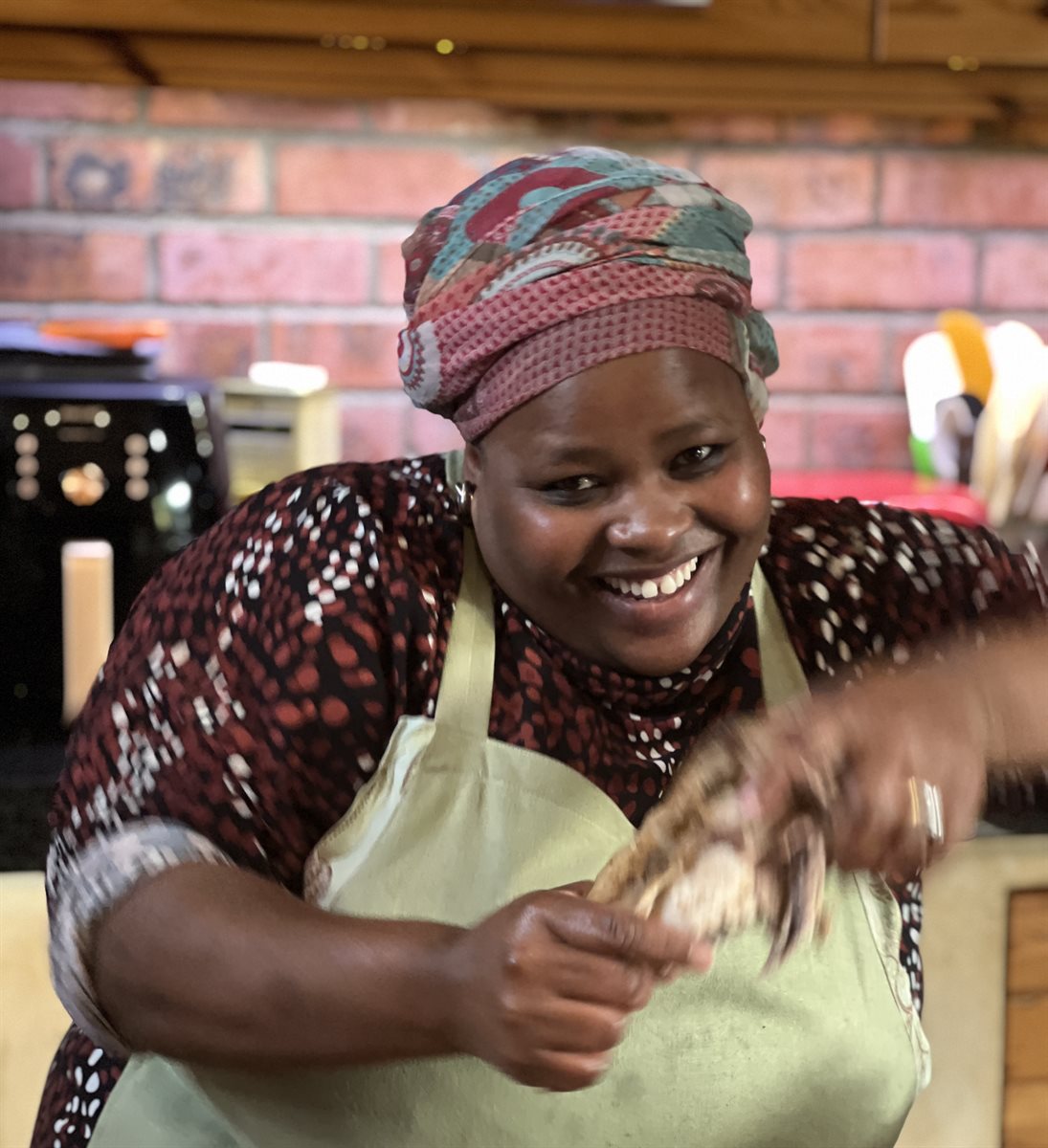A team member (Norinkie) laughing mid-bake in the kitchen — the joy behind every cake