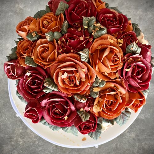 Overhead view of buttercream roses in deep red and burnt orange