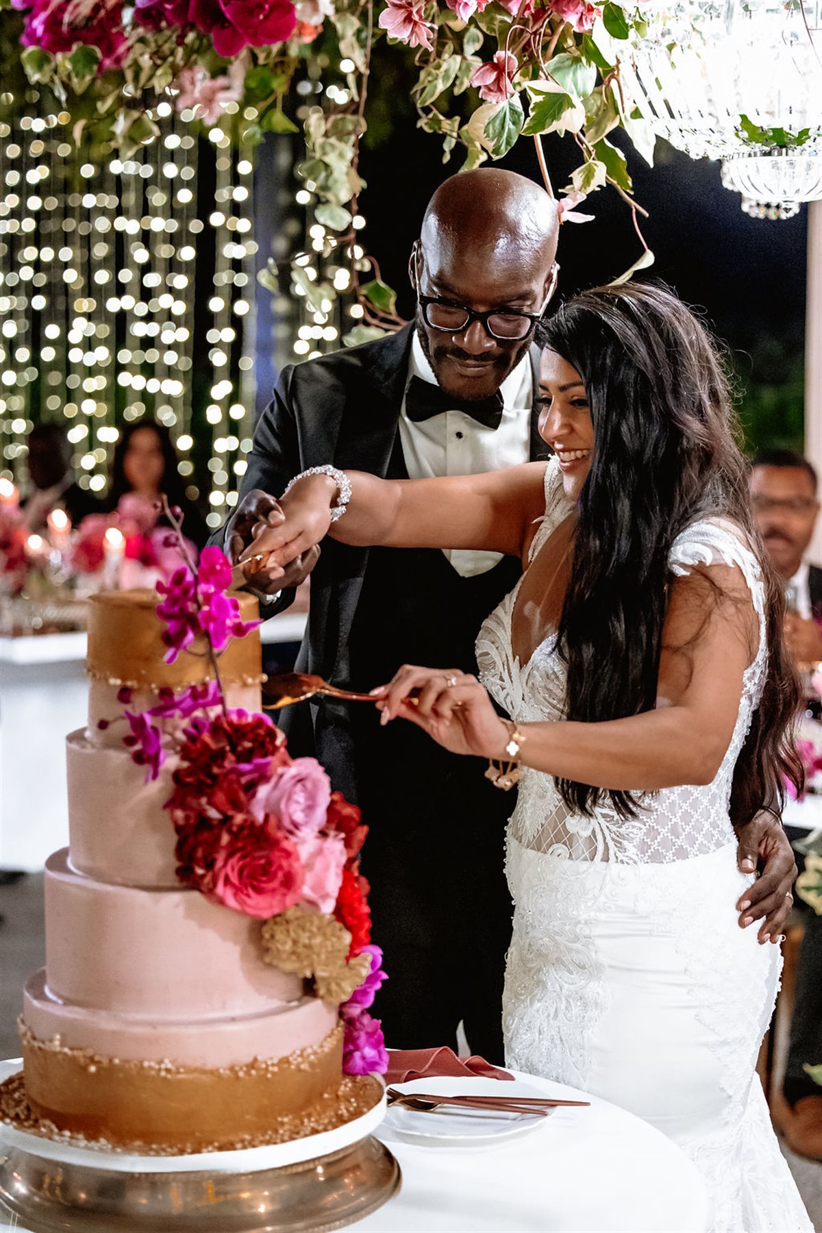 Striking couverture chocolate cake adorned with bold coloured blooms in a floral editorial setting