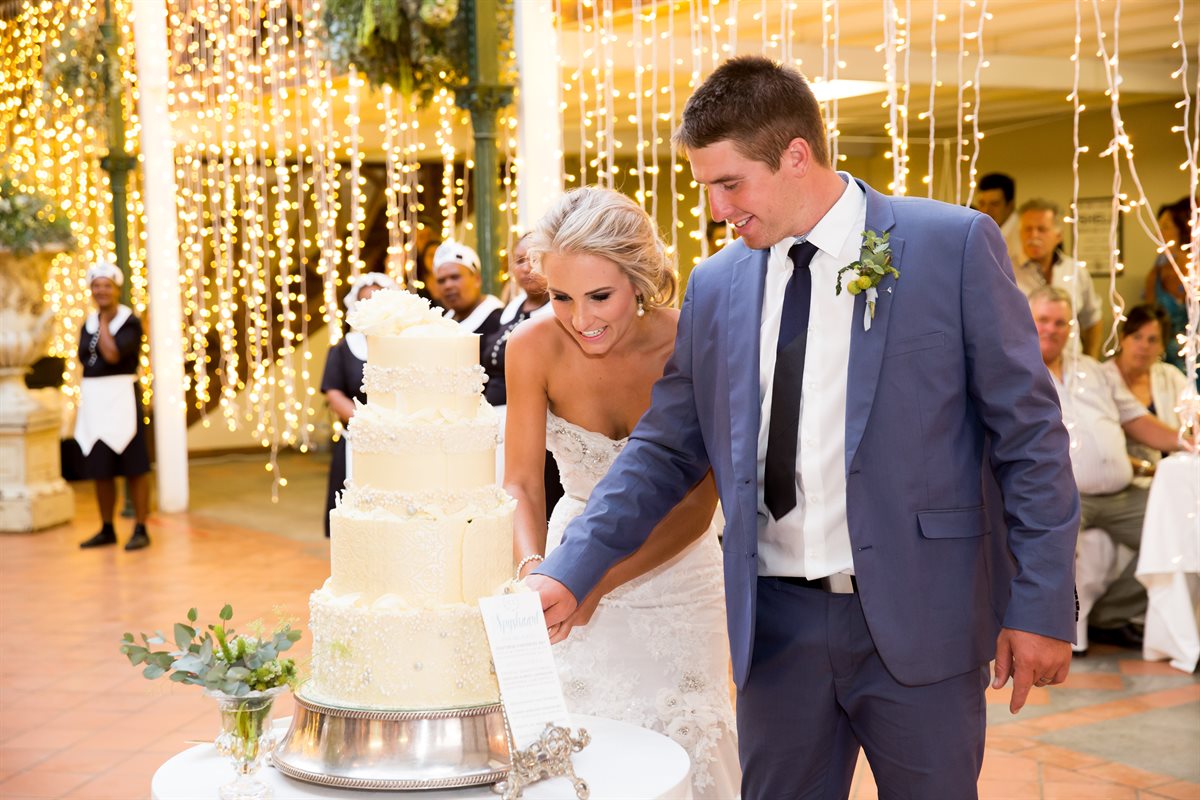 Four-tiered couverture chocolate lace wedding cake displayed at a reception