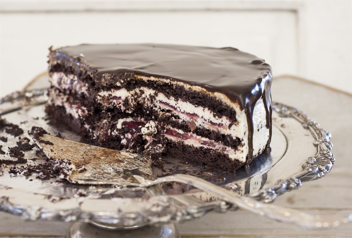 Rich black forest cake cut open — chocolate ganache top, dark cocoa sponge with cherry filling