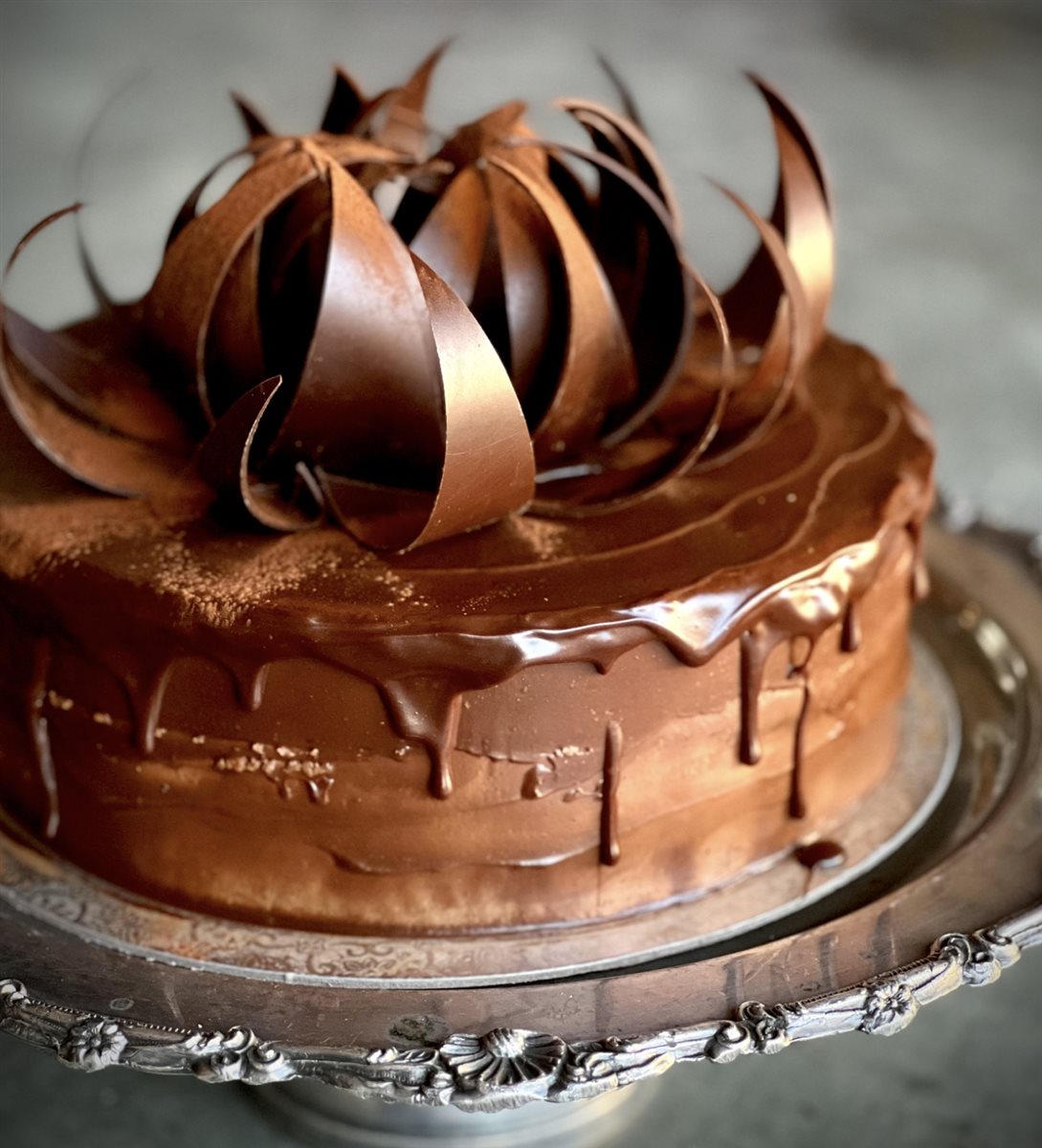 Dark chocolate ganache drip cake with a crown of large sweeping couverture chocolate curls