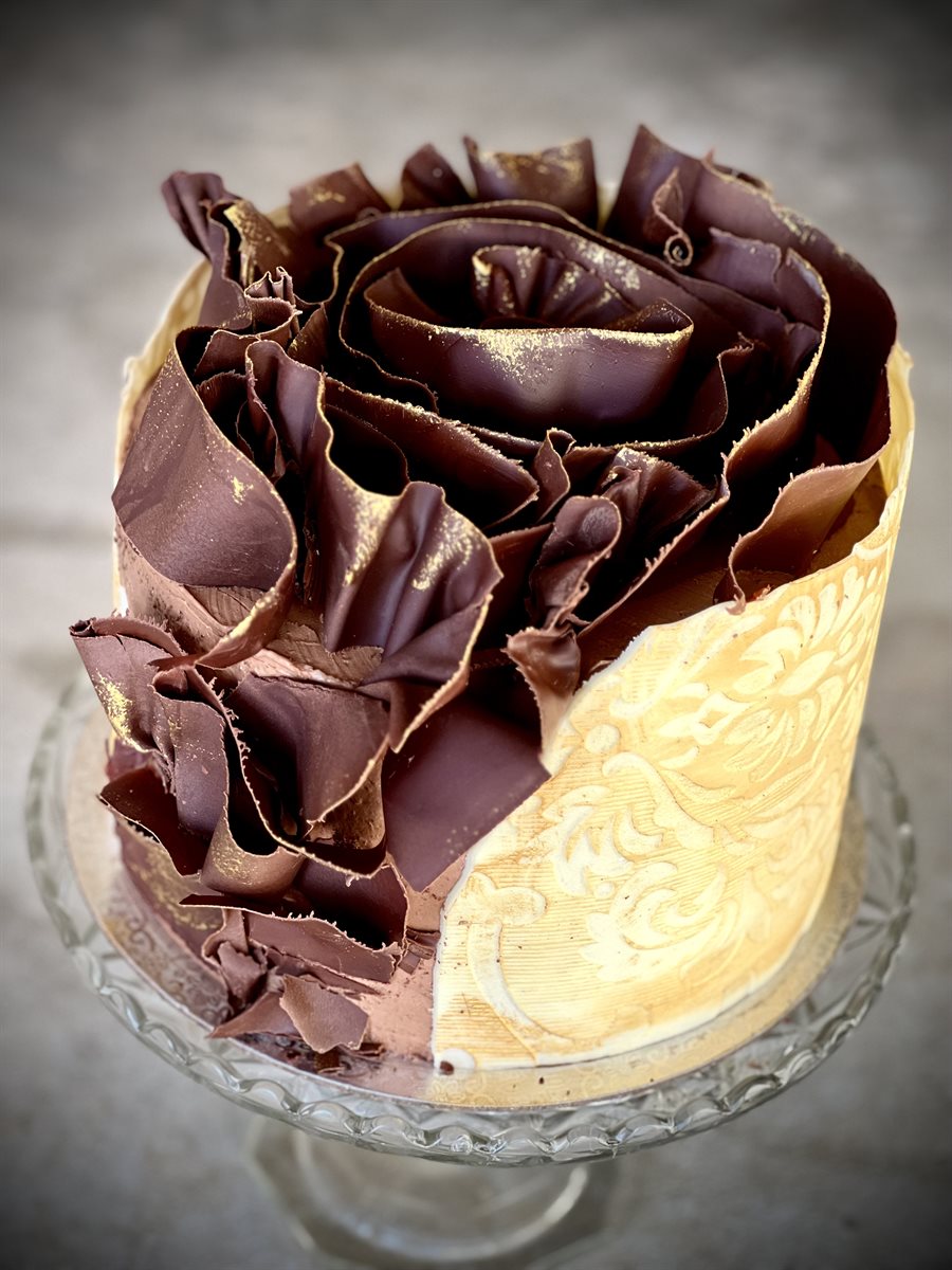 Cake with half gold-embossed damask surface and dark chocolate gold-dusted petals on the other half