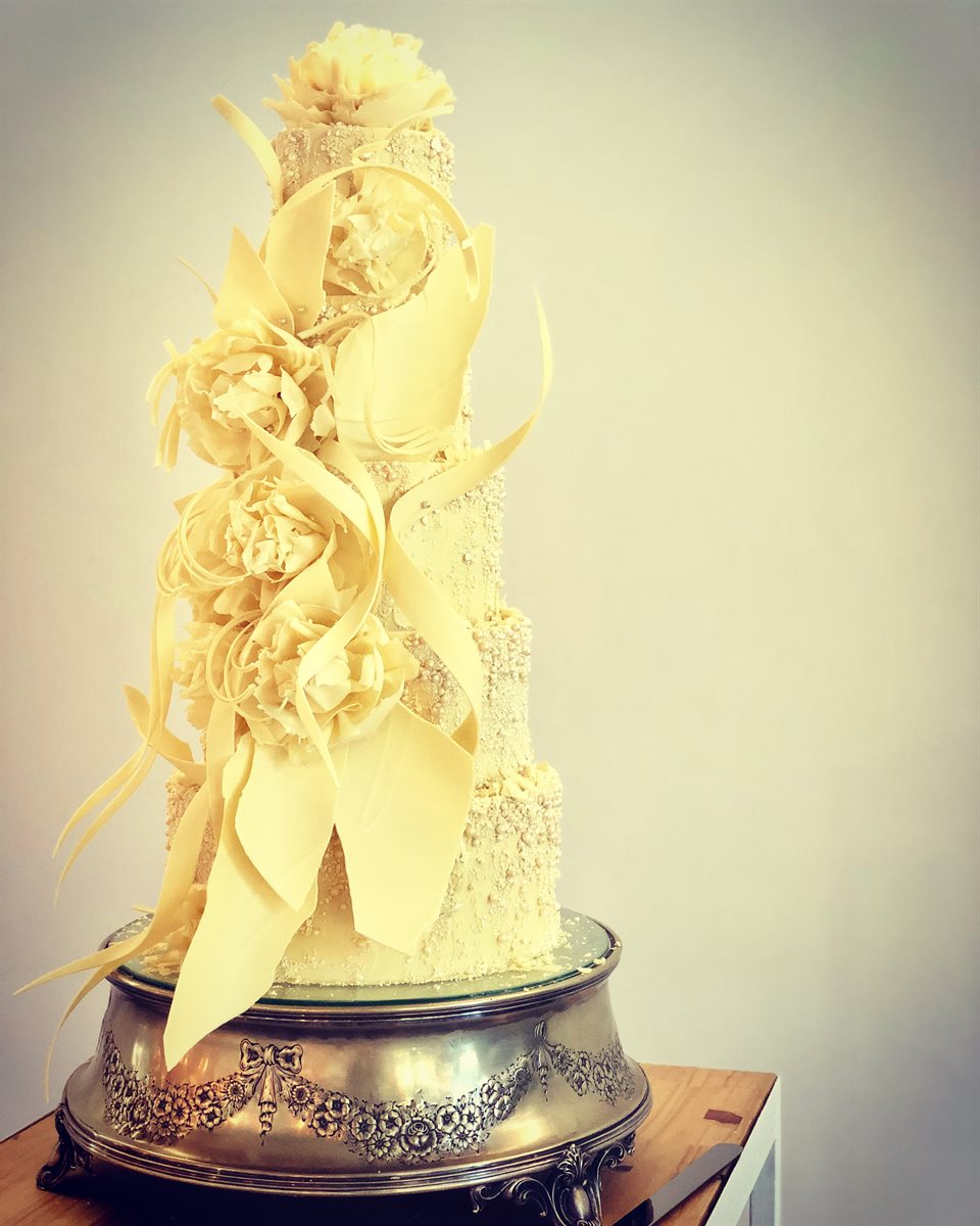 Tall ivory white chocolate peony tower with scrolled curls and pearl-studded finish