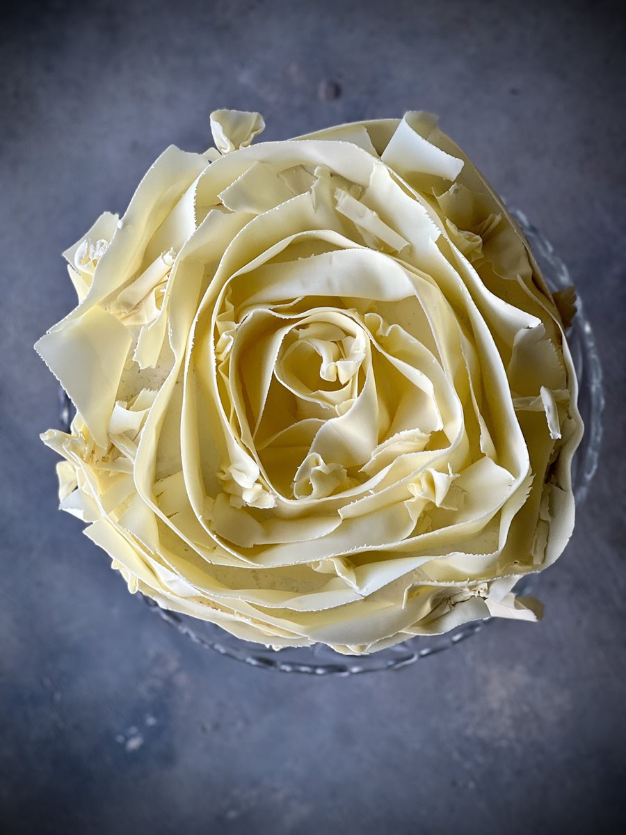 Aerial top-down view of single-tier white couverture petal rose cake